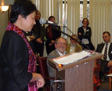 Garry Hesser looks on as Nadinne Cruz, apst executive director of HECUA gives opening remarks.